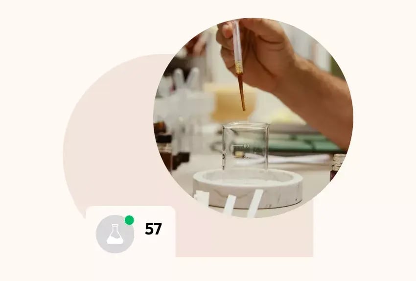 Lab beaker with a dropper adding liquid.